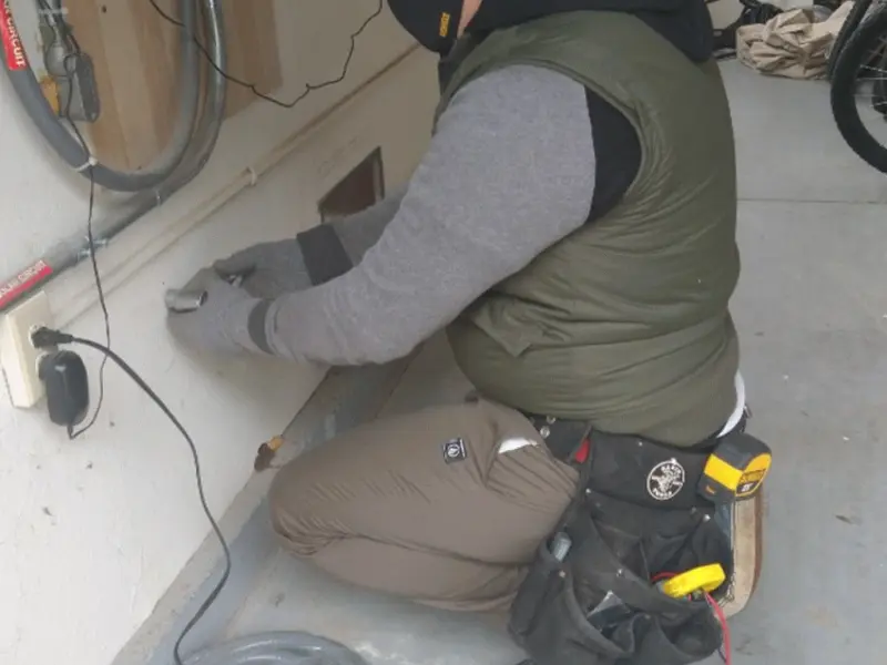 Electrician performing outlet wiring in a Winona Lake garage